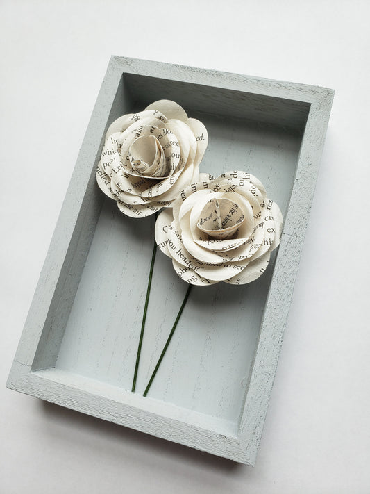 a pair of book page paper roses in a portrait shaped frame - Novel Blossoms Co