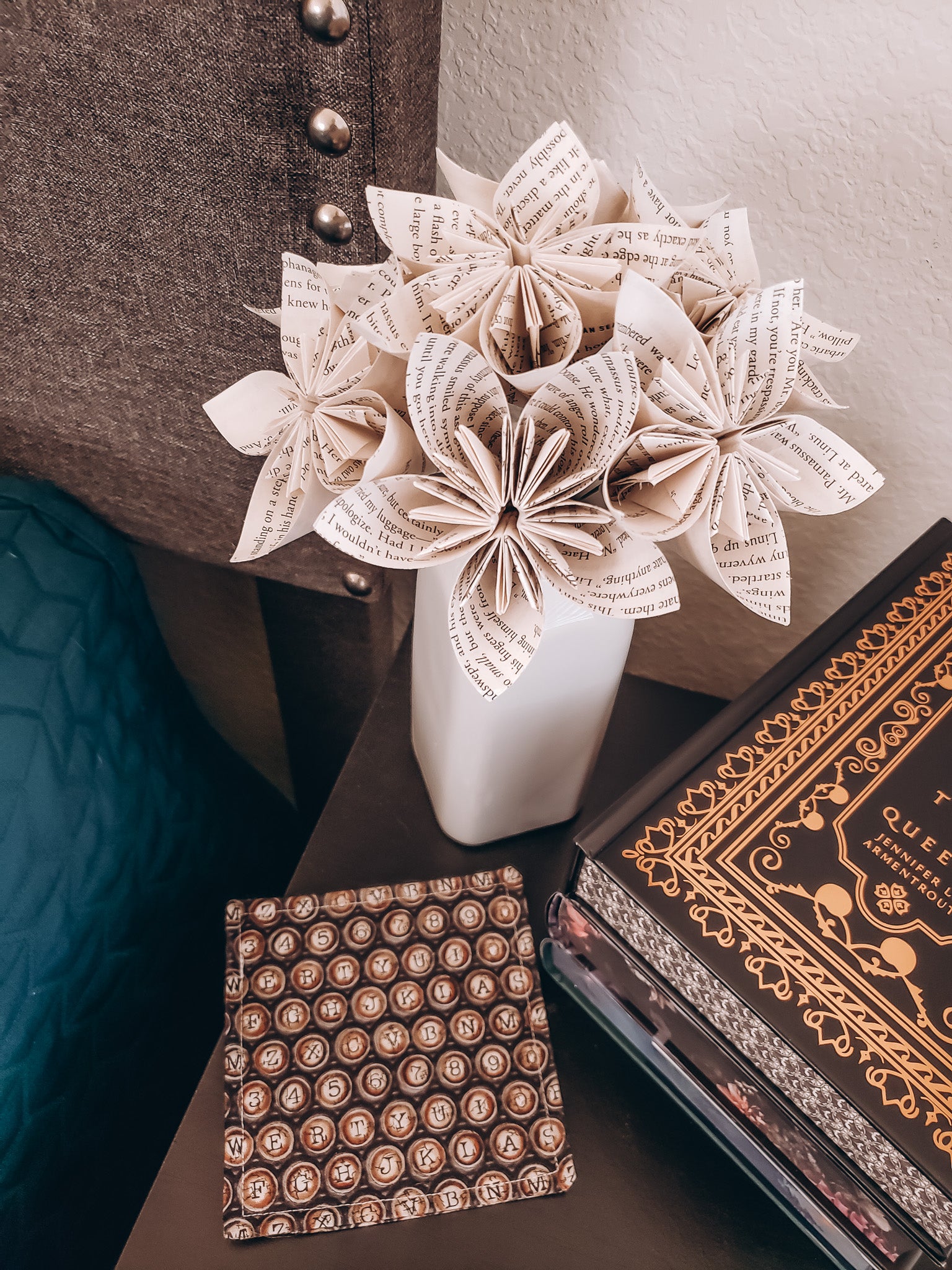 star-shaped book page paper flower bouquet siting on a nightstand next to books - Novel Blossoms Co