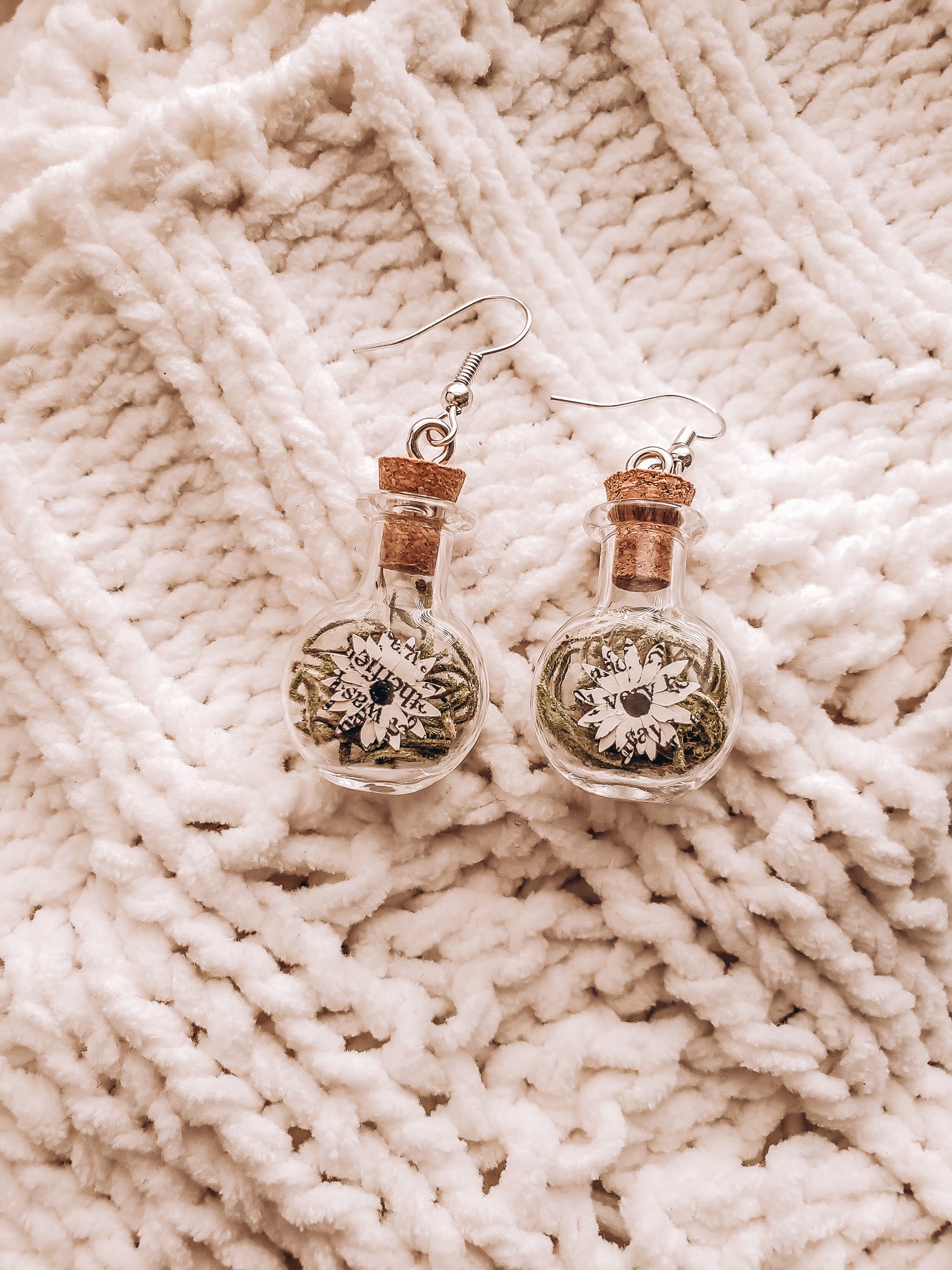 paper book page flowers in tiny glass jar earrings on top of a cozy blanket - Novel Blossoms Co