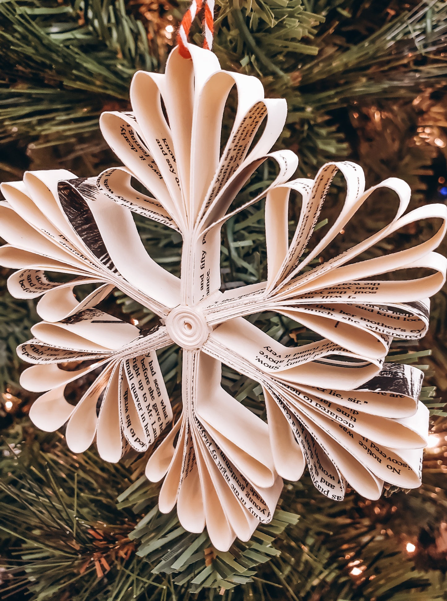 book page paper snowflake ornament on a tree - Novel Blossoms Co